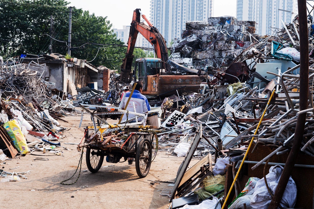 A recycler rides his tricycle in an informal sorting center for recyclable waste in Shanghai. Experts say there may be tens of thousands of such informal recyclers working in the city.