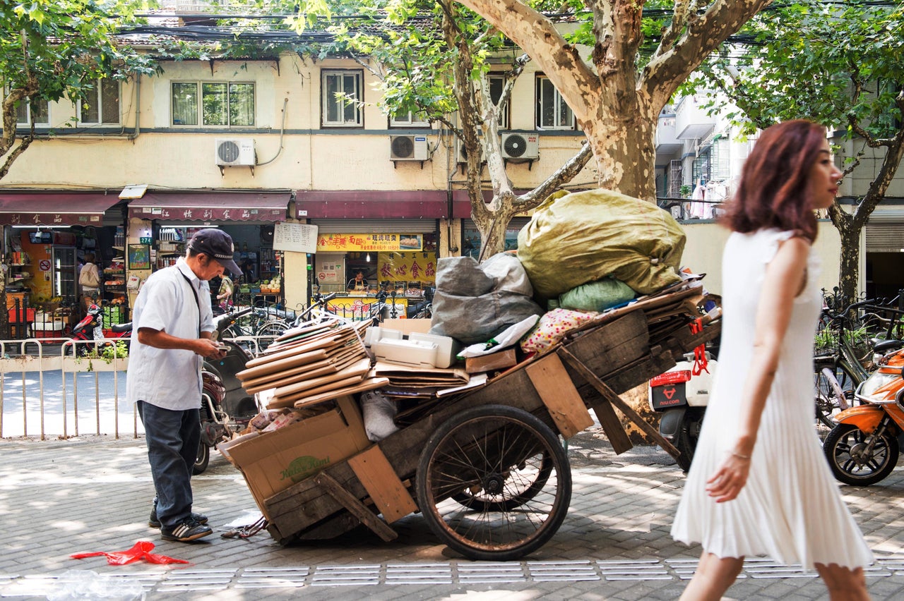 An informal recycler takes a break on a Shanghai walkway.