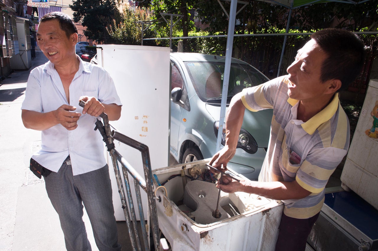 Mr. Wang, right, chats with a fellow recycler in Shanghai. Mr. Wang's collection point has become a community gathering place.