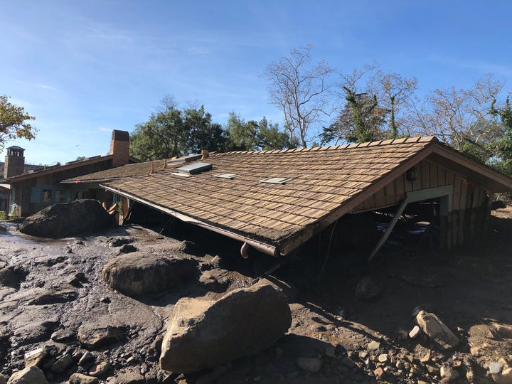 A damaged Montecito house is surrounded by dislodged boulders and debris.