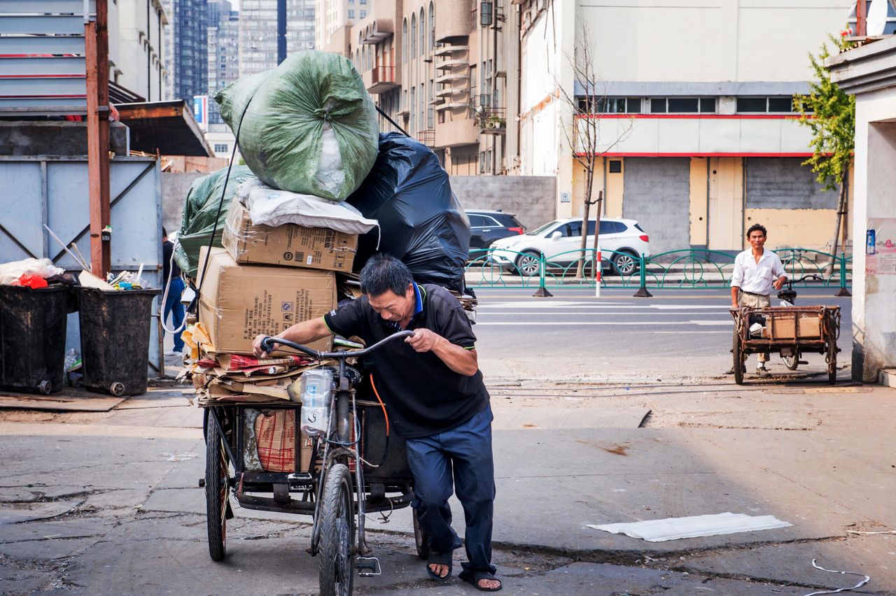 An informal recycler pushes his tricycle in Shanghai, China.