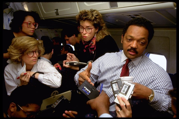 The Rev. Jesse Jackson speaks with reporters aboard a plane during a 1988 campaign stop in Ohio.