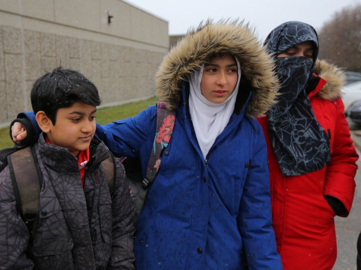 Khawlah Noman, 11, leaves Pauline Johnson Junior Public School with her mother Saima Samad (R) and brother Mohammed Zakariyya.