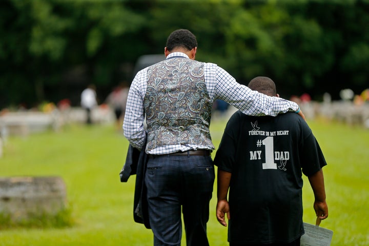 Family attorney Justin Bamber comforts Na'Quincy, son of Alton Sterling, at his father's burial on July 15, 2016.