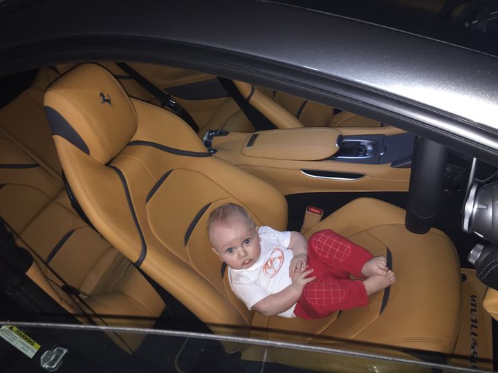Baby Joseph Khouri sitting in the drivers seat in the Ferrari GTC4LUSSO.