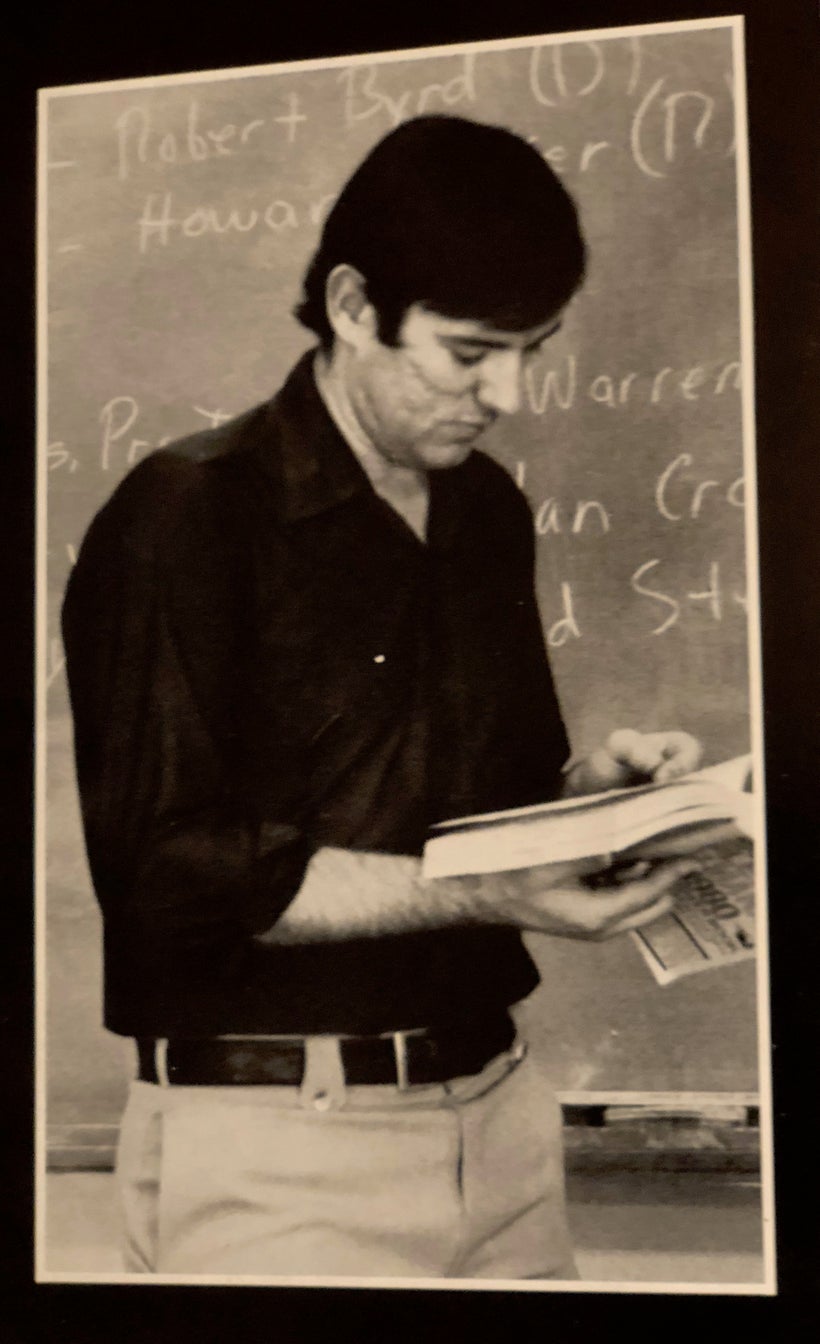 Myrrl Byler pausing in his teaching in front of the blackboard at Hartville Christian School.