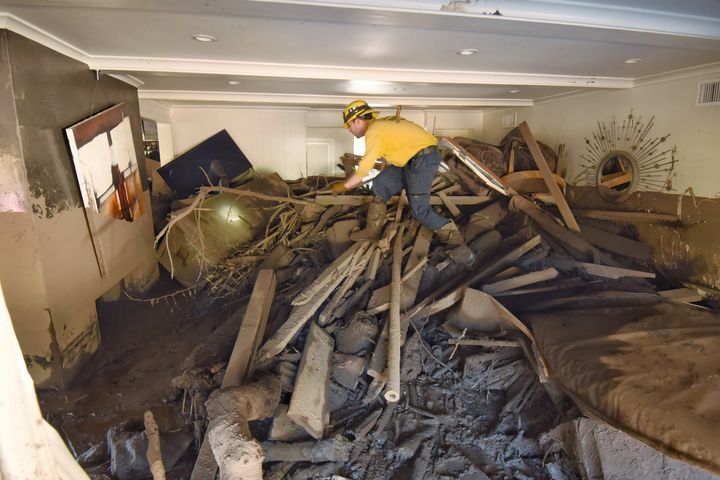 A Santa Barbara County Firefighter searches through a home that was destroyed by mudflow and debris.