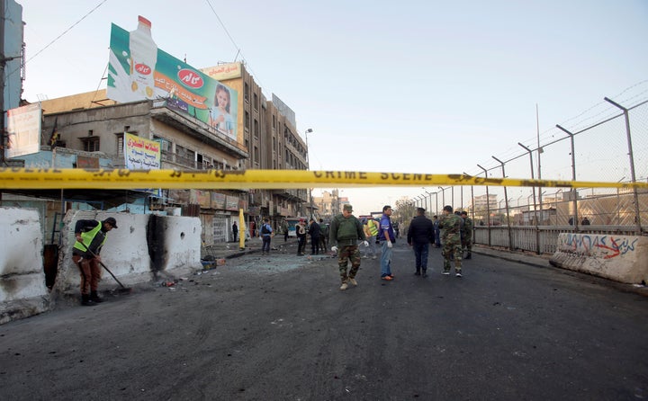 Iraqi security forces inspect the site of a bomb attack in Baghdad on Monday.