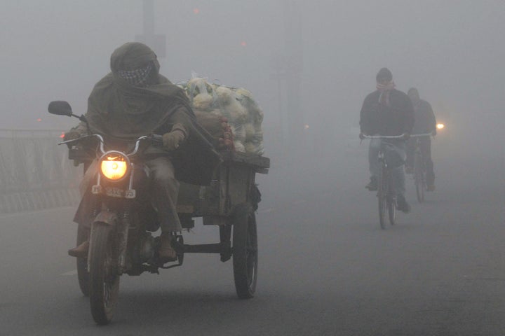 Indian commuters make their way through heavy air pollution and fog in Amritsar.