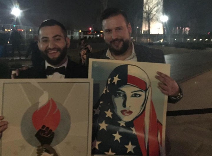 Askaryar and a friend hold posters in front of the Washington Monument.