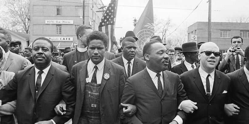 Dr. Martin Luther King, Jr. locks arms with his aides as he leads a march of several thousands on March 17, 1965 in Montgomer