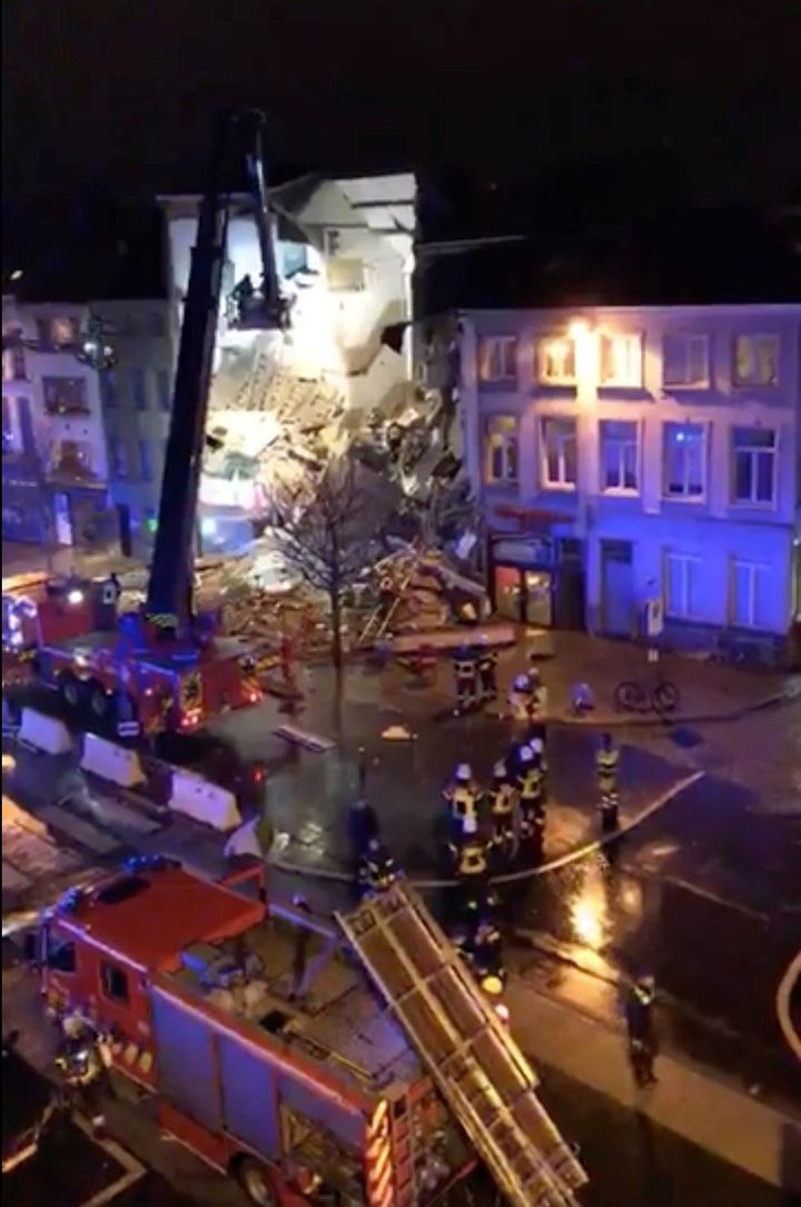 Emergency rescue personnel attend to the scene where a building has collapsed in Antwerp, Belgium.
