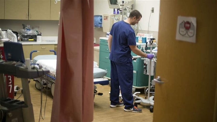 A paramedic cleans equipment in an exam room at Grady Memorial Hospital in Atlanta. Safety net hospitals such as Grady are fa