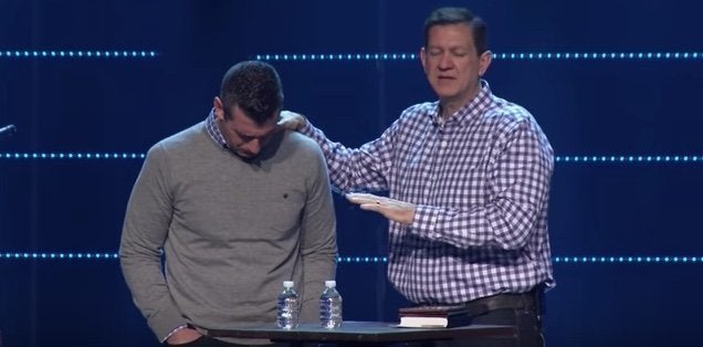 Highpoint's lead pastor Chris Conlee prays for Savage.