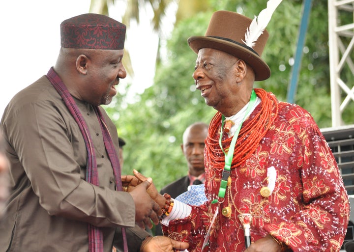Rochas Okorocha, governor of Imo state, shakes hands with King Godwin Gininwa during the launch of an oil pollution cleanup. Okorocha has appointed a minister for happiness.