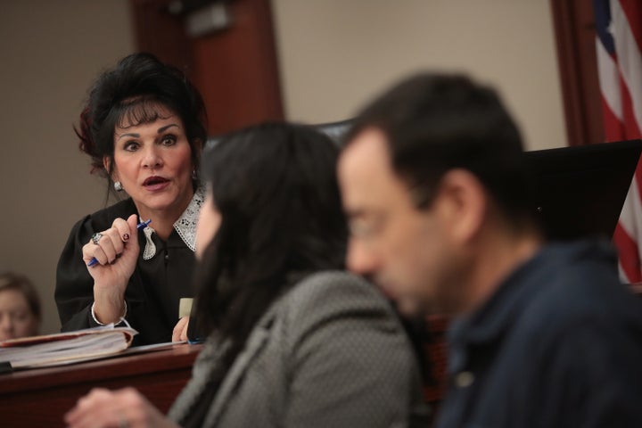 Judge Aquilina speaks with Nassar and his attorney as he appears in court to listen to victim impact statements prior to being sentenced.