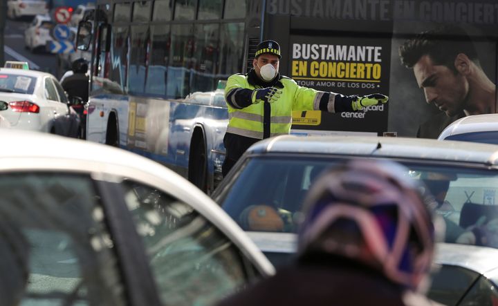 A traffic policeman wears a mask while directing traffic in Madrid on Dec. 29, 2016. 