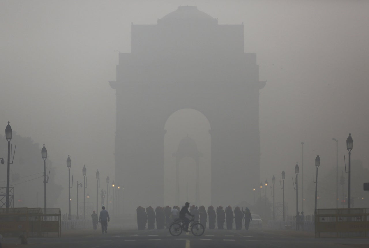 A man rides his bicycle in front of India gate in New Delhi.