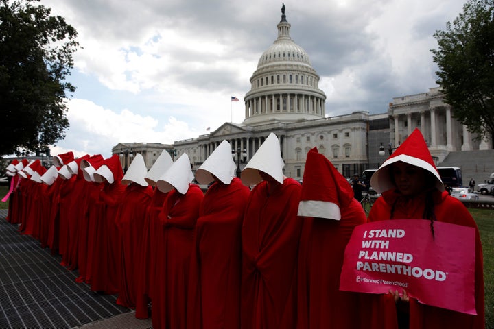 Women dressed as handmaids from "The Handmaid's Tale" demonstrate against cuts for Planned Parenthood in the Republican Senate health care bill at the U.S. Capitol in Washington, D.C., on June 27, 2017.