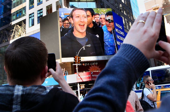 Facebook CEO Mark Zuckerberg's celebration after the company's IPO launch is seen on a screen in New York City.