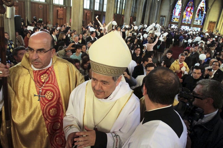 Bishop Juan Barros, center, attends his first religious service as citizens protest at the Osorno cathedral south of Santiago on March 21, 2015.