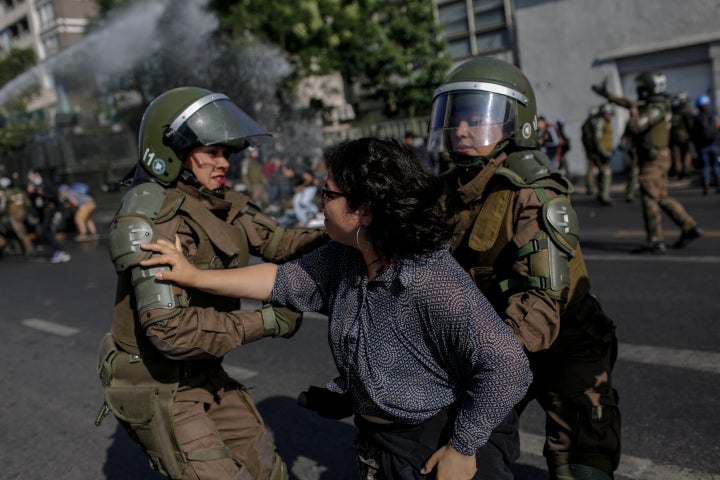 Police officers confront a demonstrator during a protest against Pope Francis in Santiago on Tuesday.