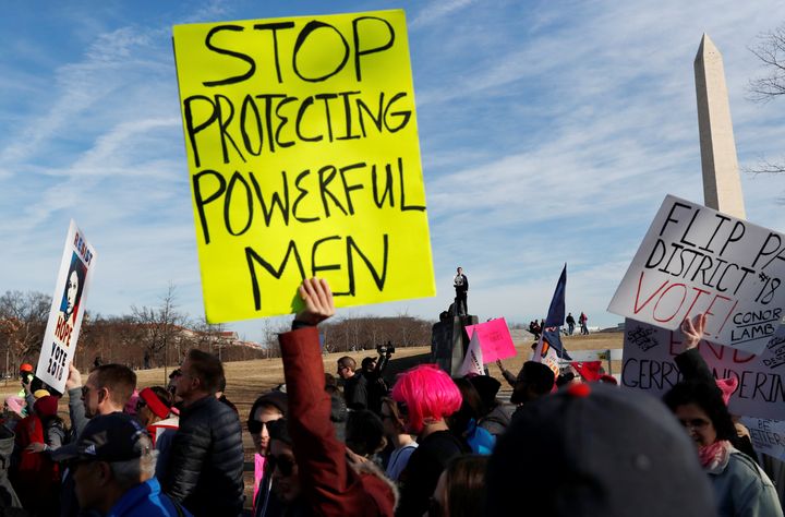 People hold placards at the second Women's March in Washington DC.