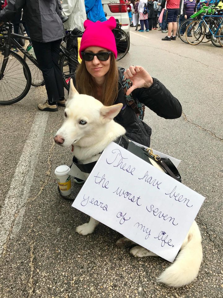Stephanie Rzepka and her dog Hattie, wearing a sign reading