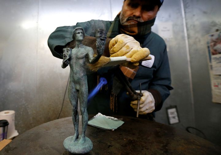 A worker applies a patina on "The Actor" statuette on January 9, 2018.