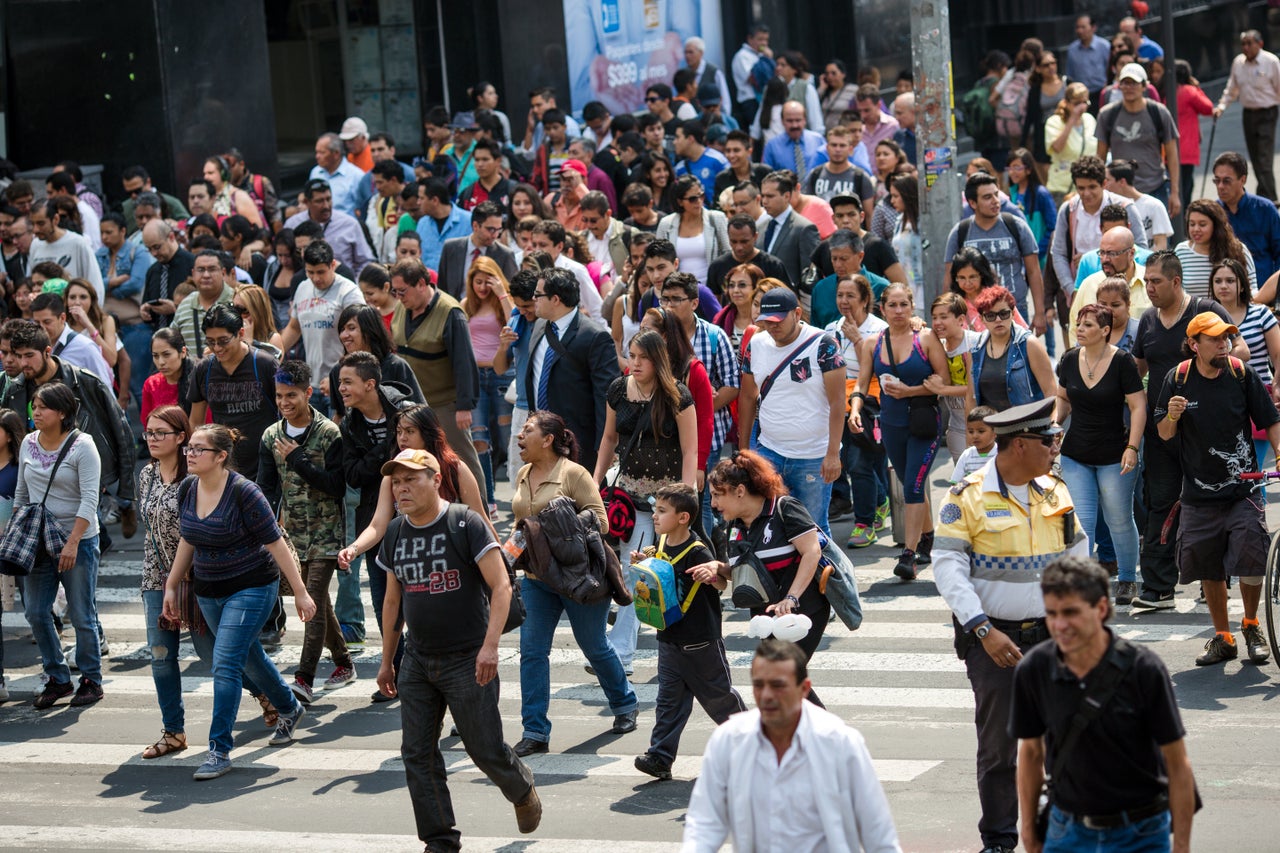 Pedestrians cross a street in downtown Mexico City. Many residents say they can feel the effects of air pollution in the city.