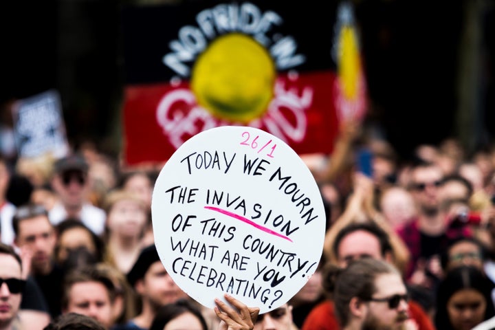 A protester holds a banner during a demonstration on Australia Day 2017. 