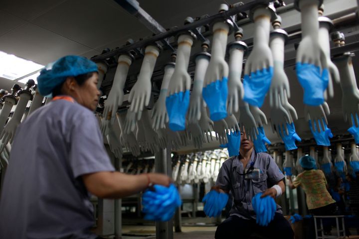 Workers on a rubber glove assembly line at a factory in Shandong Province, China. 