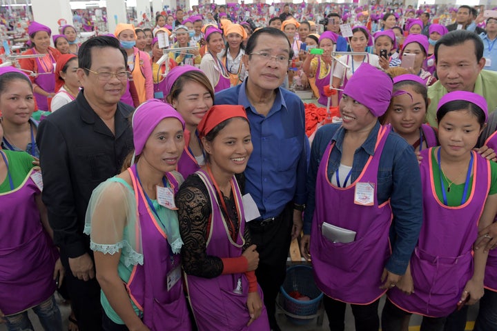 Cambodian Prime Minister Hun Sen, center, poses with garment workers at a factory on the outskirts of Phnom Penh.