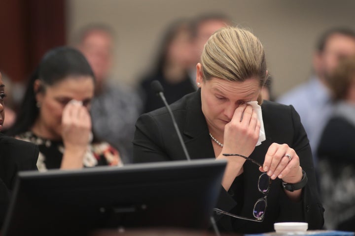 Gina Nichols, mother of victim Maggie Nichols, and Assistant Attorney General Angela Povilaitis wipe tears from their eyes as they listen to Gwen Anderson deliver a victim impact statement.