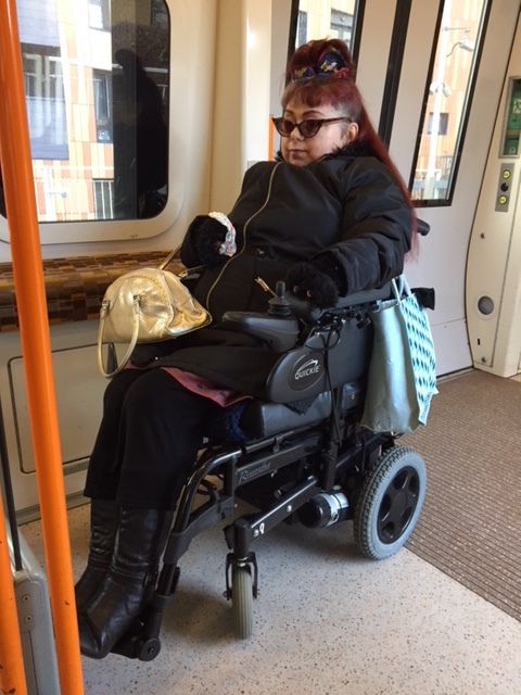 Penny in her power chair, on the overground train to Stratford East