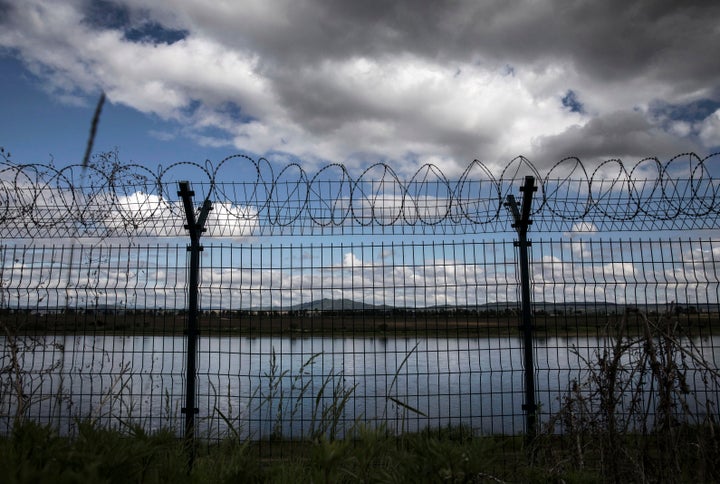 A fence with razor wire marks the Chinese border with North Korea along the Yalu River.