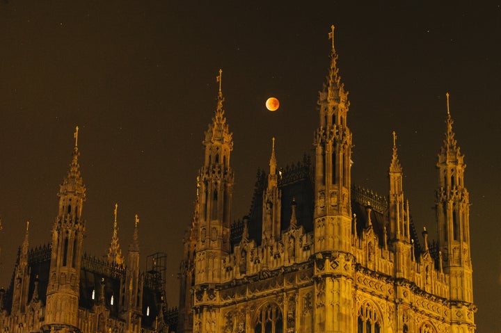 A super blood moon rises over the spires of the House of Parliament on September 28, 2015, in London, United Kingdom.