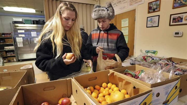 Sunny Larson, left, and Zak McCutcheon gather provisions at a food bank in Maine. Some state lawmakers are proposing new work requirements for people receiving food stamps.