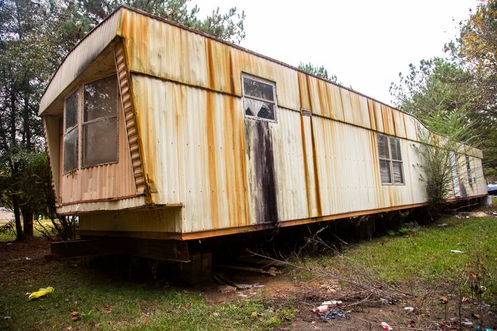 A trailer in a secluded hillside community Lowndes County, Alabama, pipes bathroom waste onto the ground.