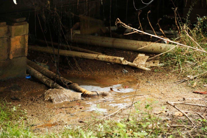 A trailer in a secluded hillside community Lowndes County, Alabama, pipes wastewater onto the ground.