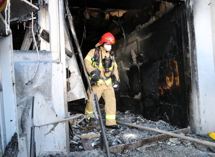 A firefighter walks out of a burnt hospital in Miryang South Korea.