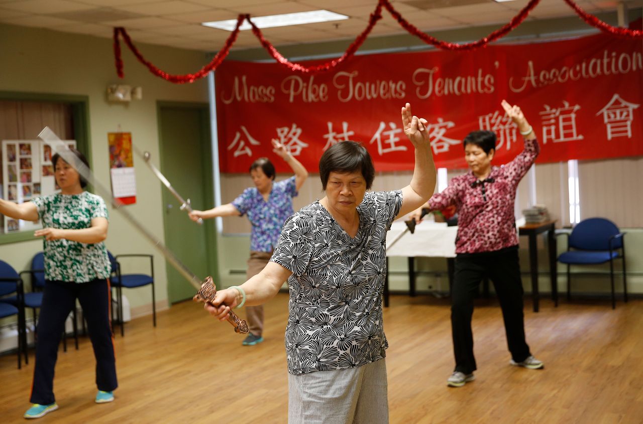 Residents of Mass Pike Towers, Boston, practice a Tai Chi sword routine.