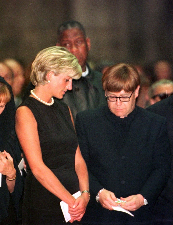 Princess Diana comforts Elton John during a mass for Italian fashion designer Gianni Versace in Milan, July 22. &nb