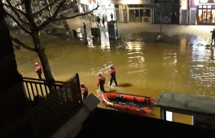 Rescue crews wade through the flood water