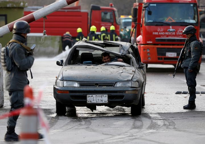 A man drives his damaged car at the site of the bombing