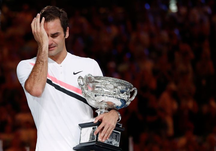 Roger Federer cries as he holds his trophy on January 28, 2018.