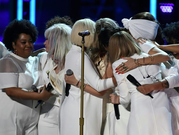 The women on stage embrace