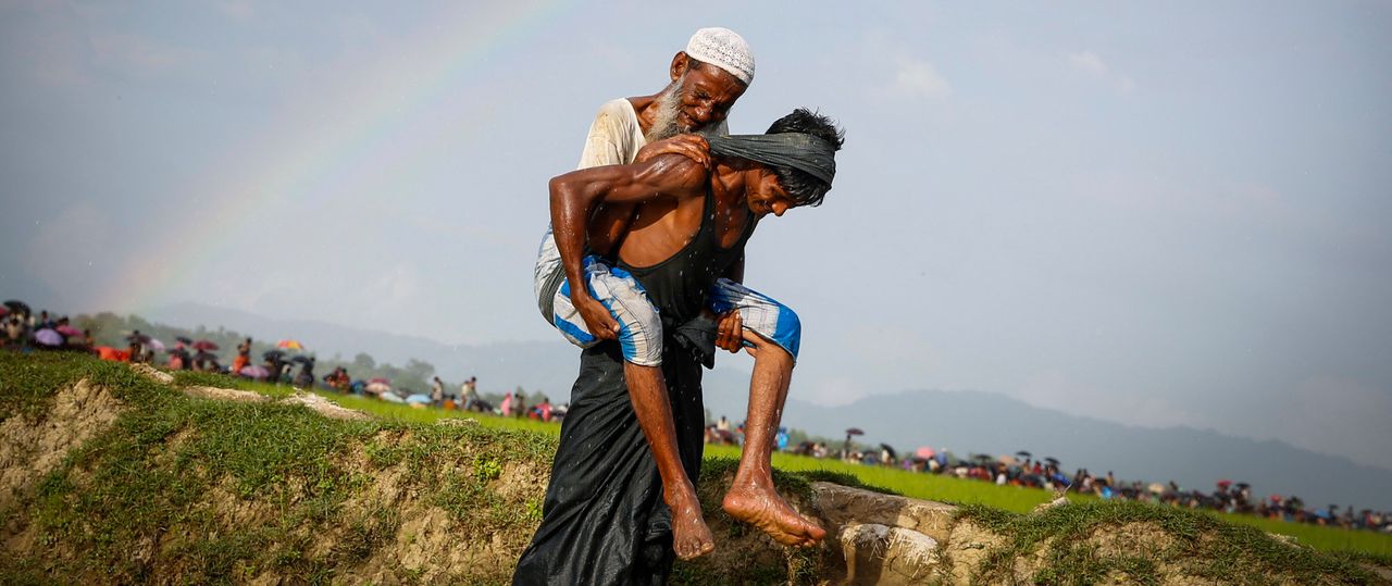 A man carries an elderly Rohingya refugee in Kutupalong, Bangladesh. 