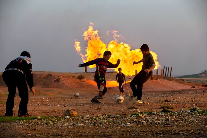 Teenagers play near an oil refinery outside the city of Kirkuk in Iraqi Kurdistan.
