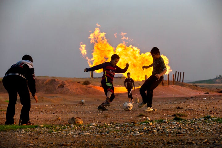 Teenagers play near an oil refinery outside the city of Kirkuk in Iraqi Kurdistan.